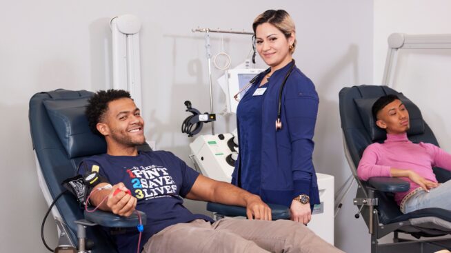 Smiling male donating blood being attended to by NCBB phlebotomist.